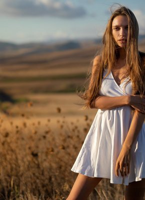 Стройная девушка позирует голой на природе